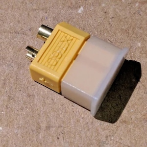 May include: A yellow connector with two gold-colored pins and a white protective cover. The connector has the text "X-CELL" printed on it.