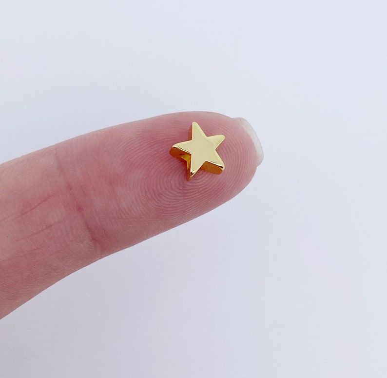 May include: A small gold star charm, ideal for adding a touch of sparkle to jewellery or crafts.
