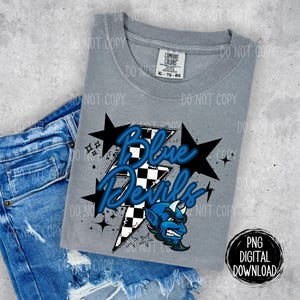 May include: A gray t-shirt with a blue and white checkered lightning bolt design. The design includes the text "Blue Devils" and a cartoon blue devil with horns. The text "PNG Digital Download" is in the lower right corner.