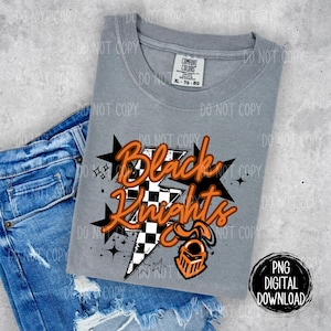 May include: A gray t-shirt with a black and orange graphic design that says "Black Knights". The graphic features a lightning bolt with a checkered pattern and a knight's helmet.