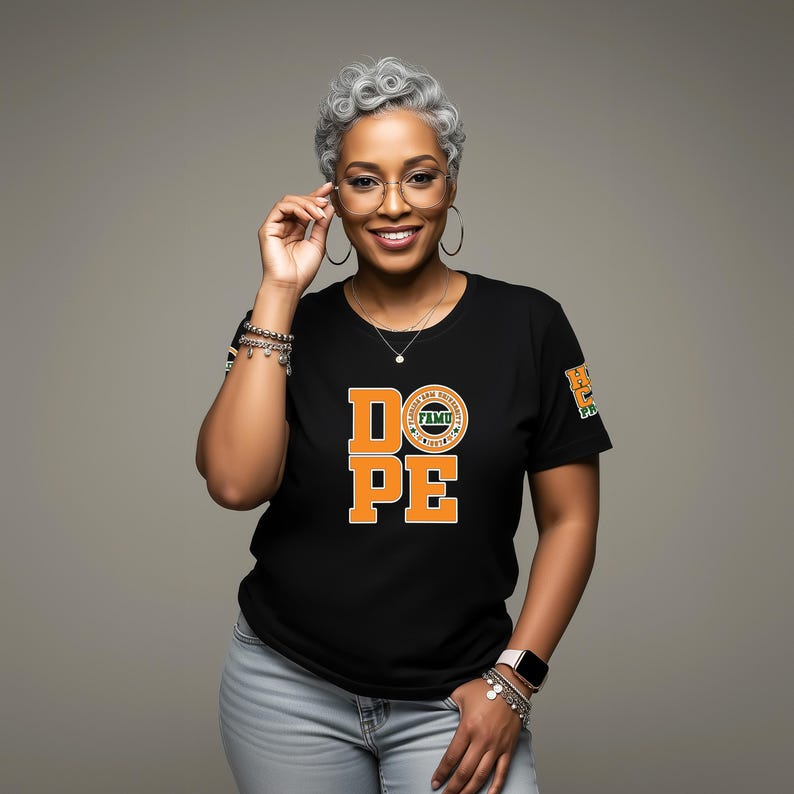 May include: Black t-shirt with the word "DOPE" in orange block letters. The shirt also features a circular logo and a small emblem on the sleeve. The person in the image is wearing glasses and jewelry.