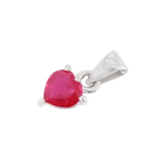 May include: A silver pendant with a red heart-shaped gemstone.