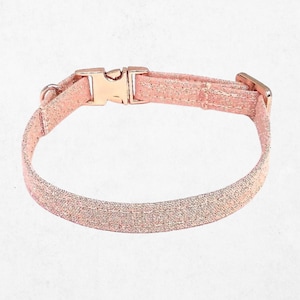 A pink glittery dog collar with a buckle.