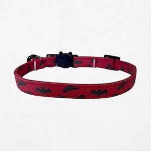 A red dog collar with a pattern of bats printed on it.