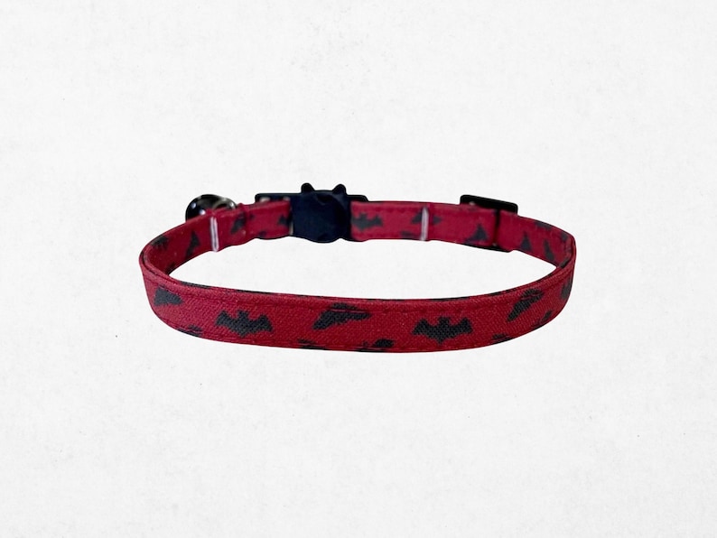 A red dog collar with a pattern of bats printed on it.