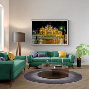 Pu&ograve; includere: Un interno di soggiorno con un divano verde, un tavolino da caff&egrave;, una lampada da terra e una fotografia incorniciata di un edificio di notte. Il divano ha cuscini viola e gialli. Il tavolino da caff&egrave; &egrave; rotondo e ha un piano in vetro. La lampada da terra &egrave; in legno e ha un paralume grigio. La fotografia &egrave; di un edificio con una cupola e una torre dell'orologio. L'edificio &egrave; illuminato di notte e ci sono persone che camminano di fronte ad esso.