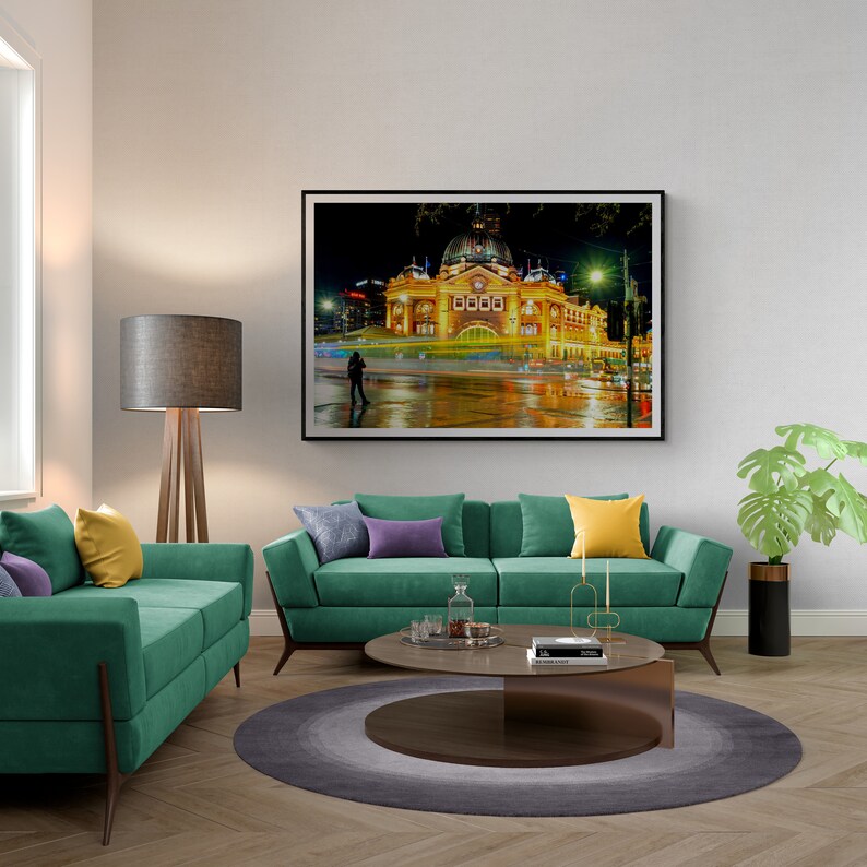 Pu&ograve; includere: Un interno di soggiorno con un divano verde, un tavolino da caff&egrave;, una lampada da terra e una fotografia incorniciata di un edificio di notte. Il divano ha cuscini viola e gialli. Il tavolino da caff&egrave; &egrave; rotondo e ha un piano in vetro. La lampada da terra &egrave; in legno e ha un paralume grigio. La fotografia &egrave; di un edificio con una cupola e una torre dell'orologio. L'edificio &egrave; illuminato di notte e ci sono persone che camminano di fronte ad esso.