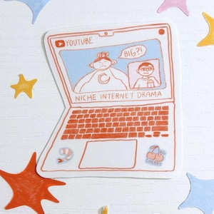 May include: A white sticker of a laptop with an orange keyboard and the text "NICHE INTERNET DRAMA". The laptop screen shows a YouTube video with the word "BIG?!" in a speech bubble. Colorful star-shaped stickers surround the laptop.
