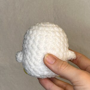 May include: A white crocheted duck plush toy with yellow accents.