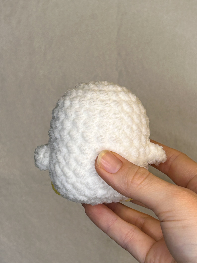 May include: A white crocheted duck plush toy with yellow accents.