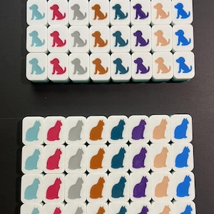 May include: A collection of white tiles, each featuring a colorful dog or cat silhouette. The tiles are arranged in rows, with various colors including blue, red, gray, orange, teal, purple, and tan. The image showcases a playful pet theme.