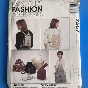 May include: McCall's Fashion Accessories pattern envelope. The envelope features images of various bags, including totes and a mini backpack. The text reads "Carry On" and "Prets a Porter". The envelope is on a blue background.