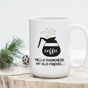 May include: White ceramic coffee mug with a black and white illustration of a coffee pot with steam coming out of it. The text "coffee" is written on the pot. The text "Hello darkness my old friend..." is written below the pot.