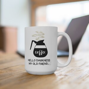 May include: White ceramic coffee mug with a black illustration of a coffee pot with steam rising from the spout. The text "coffee" is written on the pot. The text "Hello darkness my old friend..." is written below the pot.