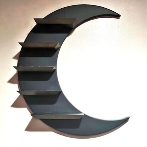 May include: A black crescent moon-shaped shelf with five shelves. The shelves are angled and made of metal.