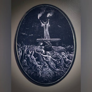May include: A black and white oval wooden plaque with a raised image of a figure in a robe raising their arms in the air. The figure is surrounded by other figures in a dark, shadowy scene.