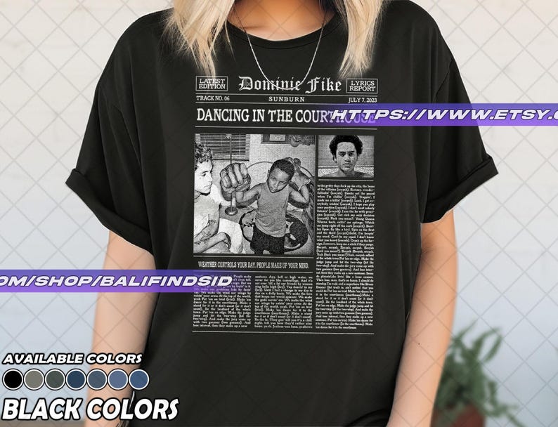 May include: Black t-shirt featuring a newspaper-style graphic with the text "Dominie Fike" and "Dancing in the Court". The graphic includes black and white images and text. The shirt also has a list of available colors.