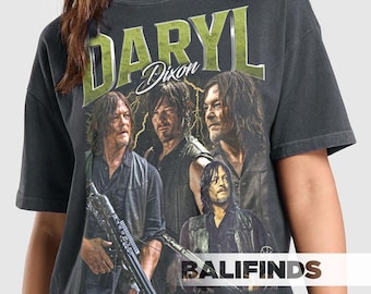 May include: Dark gray t-shirt featuring a graphic of Daryl Dixon from The Walking Dead. The design includes multiple images of the character, the name "DARYL" in large green letters, and the name "Dixon" in a script font. The shirt also has the text "BALIFINDS".
