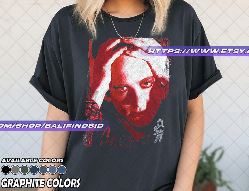 Pu&ograve; includere: T-shirt nero grafite con grafica rossa e bianca di un volto umano. La maglietta include il testo "AVAILABLE COLORS" e "GRAPHITE COLORS" con una tavolozza di colori. L'URL del negozio Etsy &egrave; visibile.