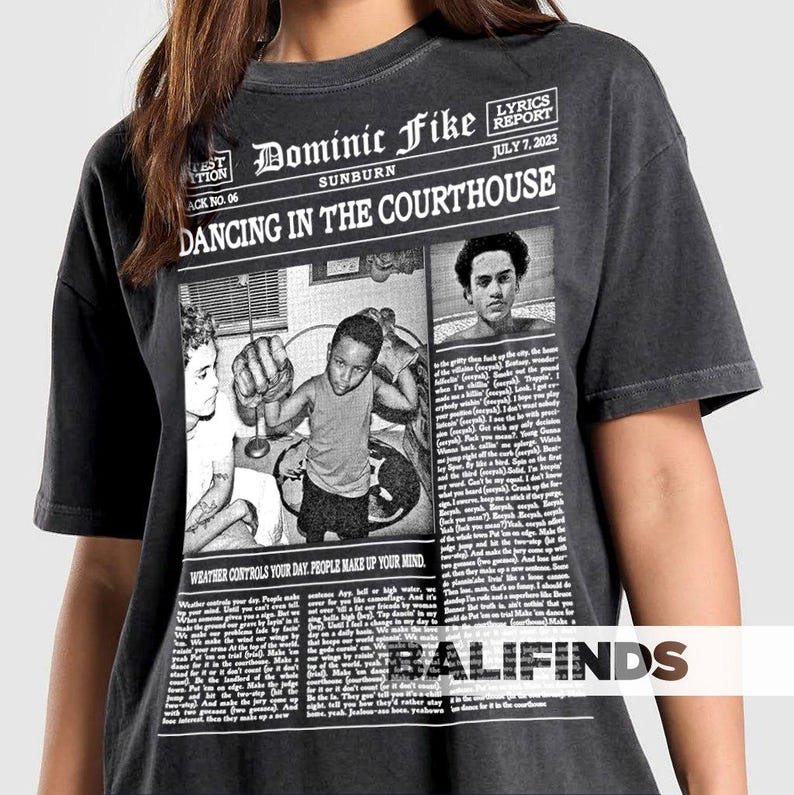 May include: A white ceramic mug with a black handle and the text "But First, Coffee" in a bold, black font. The mug is set against a blurred background, suggesting a cozy setting.