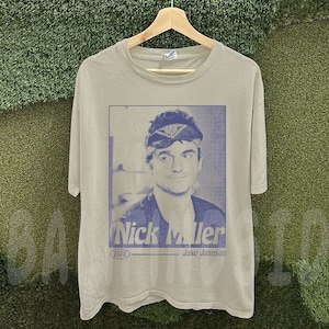 May include: A set of three ceramic mugs with a speckled, matte finish. The mugs are in shades of cream, light brown, and dark brown. Each mug has a simple, minimalist design and a rounded handle.