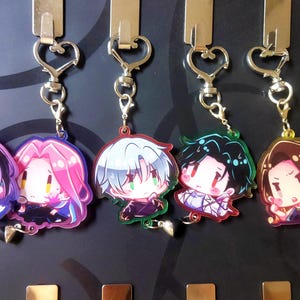 May include: Set of eight colorful anime character keychains. Each keychain features a different character with a unique design and vibrant colors. The keychains are made of clear acrylic and have a silver metal ring.