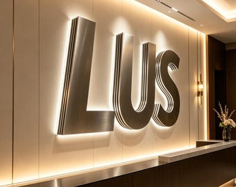 Puede incluir: Una moderna zona de recepción de oficina con un gran letrero "LUS" iluminado en plata contra una pared crema. El mostrador de recepción es de madera oscura con una encimera de acero inoxidable y una encimera de mármol. La iluminación cálida realza el espacio.
