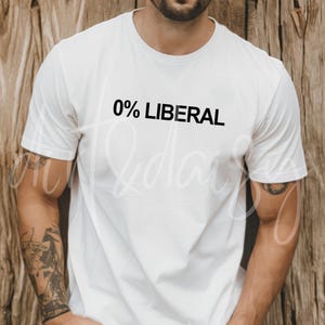 May include: White t-shirt with the text "0% LIBERAL" in black. The shirt is short-sleeved and appears to be made of a soft material. The background is a wooden wall.