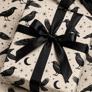 May include: Gift-wrapped presents with black satin bows. The wrapping paper features a cream background with black illustrations of crows, moons, and stars. The bows are tied in a classic style, adding a touch of elegance.