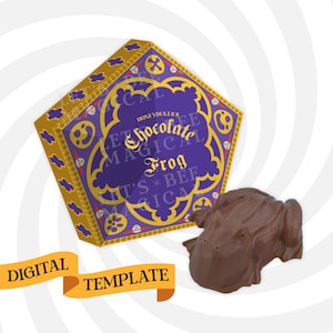 Puede incluir: Una rana de chocolate y su caja. La caja es morada y dorada con el texto "Honeydukes Chocolate Frog". La rana es marrón y está al lado de la caja. Un banner de plantilla digital está en la parte inferior.
