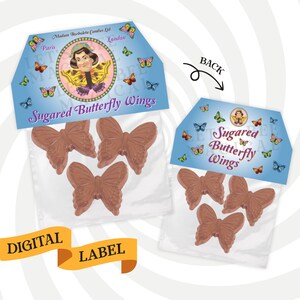 May include: A clear plastic bag with a label that says "Sugared Butterfly Wings" and features a cartoon woman with a butterfly on her head. The bag contains three chocolate butterfly wings.