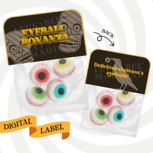 Op de afbeelding: Een doorzichtige plastic zak gevuld met kleurrijke gummy oogballen. De zak heeft een zwart en gouden label met de tekst "Let's Bee Eyeball Bonanza" en "Magic". De achterkant van de zak heeft een zwart en gouden label met de tekst "Delicious skeleton's eyeballs!" en "Magic".