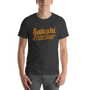 Puede incluir: Una camiseta gris oscuro jaspeada con el texto "Satoshi Stacker" en naranja.