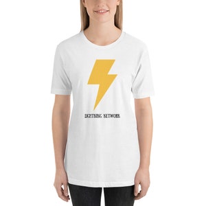 Puede incluir: Camiseta blanca con un gráfico de rayo amarillo y el texto "Lightning Network" impreso debajo.
