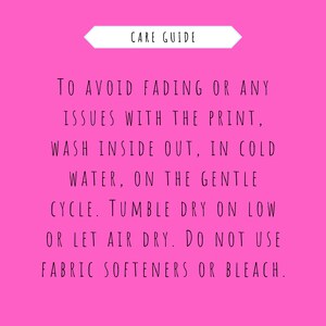 May include: Pink background with white text outlining care instructions for a garment. The text reads: "CARE GUIDE TO AVOID FADING OR ANY ISSUES WITH THE PRINT, WASH INSIDE OUT, IN COLD WATER, ON THE GENTLE CYCLE. TUMBLE DRY ON LOW OR LET AIR DRY. DO NOT USE FABRIC SOFTENERS OR BLEACH."
