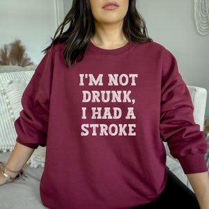 May include: Burgundy sweatshirt with white text that reads "I'm not drunk, I had a stroke."