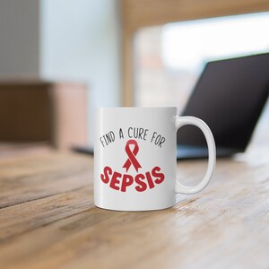 May include: White ceramic coffee mug with a red ribbon and the text "Find a Cure for Sepsis".