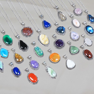 May include: A collection of 25 silver necklaces with various gemstone pendants. The pendants are in a variety of shapes and colours, including blue, green, red, orange, and purple.