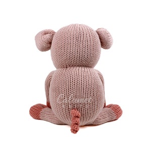 May include: A pink knitted pig plush toy sitting on a white background. The pig has a curly tail and pink ears.
