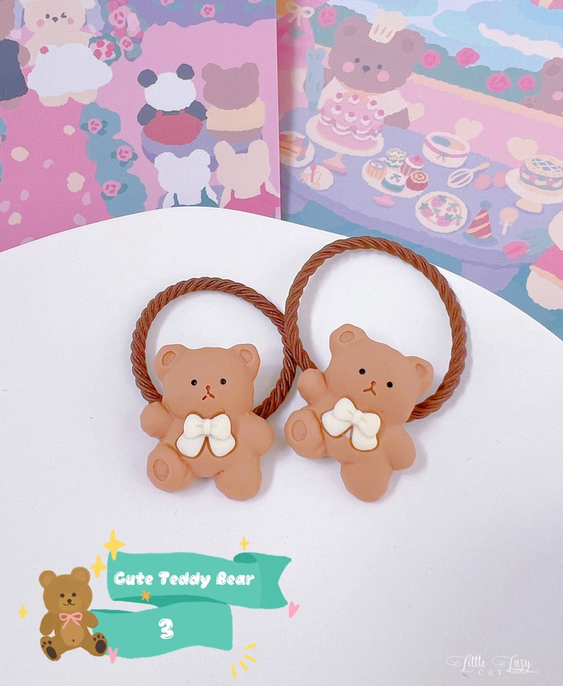 May include: Two brown teddy bear hair ties with white bows. The hair ties have a brown, twisted rope design. The image also includes a graphic that says "Cute Teddy Bear" and the number "3".