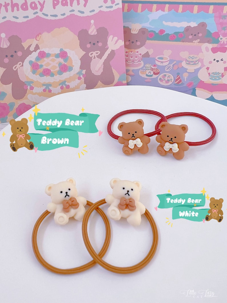 May include: Hair ties featuring small teddy bear figures in brown and white, each with a bow tie. The hair ties are on a white surface with a pink and beige background with teddy bear illustrations. The text "Teddy Bear Brown" and "Teddy Bear White" is also visible.