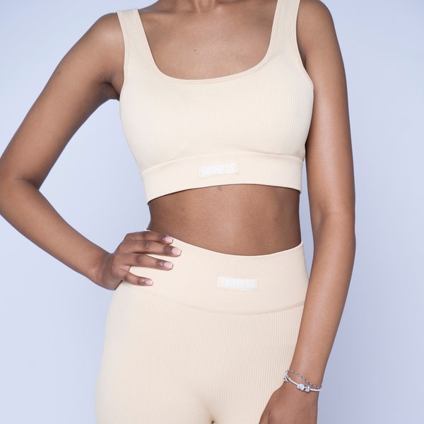 Puissance et confort en un : ensemble de sport beige clair avec longs leggings et soutien-gorge de sport assorti pour votre entraînement actif.