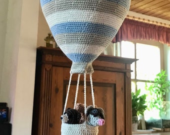 Crocheted hot air balloon with three balloonists in the basket