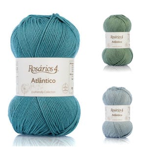 Pode incluir: Três novelos de fio em tons de azul-petróleo, verde e azul claro. Cada novelo tem uma etiqueta branca com o texto "Rosários 4 Atlântico" e "Ecofriendly Collection". O fio é bem enrolado, mostrando a textura das fibras.
