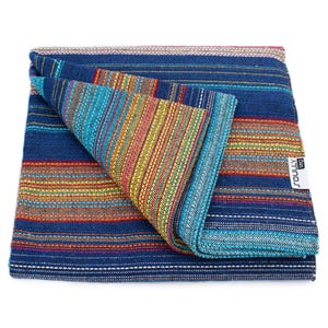 May include: A folded woven blanket featuring a vibrant striped pattern in shades of deep blue, turquoise, yellow, orange, and red. The fabric has a textured appearance with horizontal lines and a white rectangular tag labeled SOULLY tag.