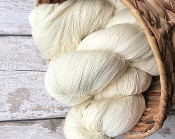 May include: A basket filled with a large amount of white yarn. The yarn is soft and fluffy, and it is perfect for knitting or crocheting.