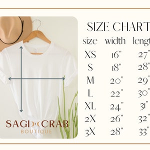 Puede incluir: Tabla de tallas para una camiseta blanca con medidas en pulgadas. La tabla muestra el ancho y la longitud de la camiseta en las tallas XS, S, M, L, XL, 2X y 3X.