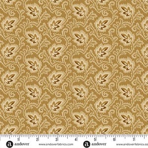 May include: A mustard yellow fabric featuring a repeating pattern of dark brown stylized leaves and intricate cream-colored lace-like scrollwork. A white ruler at the bottom shows measurements in inches, with the fabric width spanning over 7 inches.