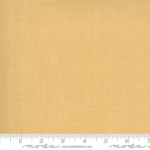 May include: A solid, pale yellow fabric with a subtle woven texture. The fabric is shown with a ruler marked in inches.