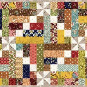 May include: A rectangular quilt with a patchwork design. The quilt features a variety of fabric patterns in shades of red, yellow, blue, green, and brown. The design includes rectangular blocks, squares, and pinwheel shapes, all set against a neutral background.